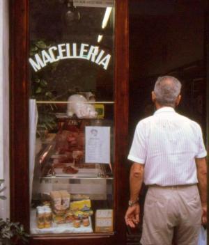 Visitor paused in front of a meat market, Porto Venere, Italy