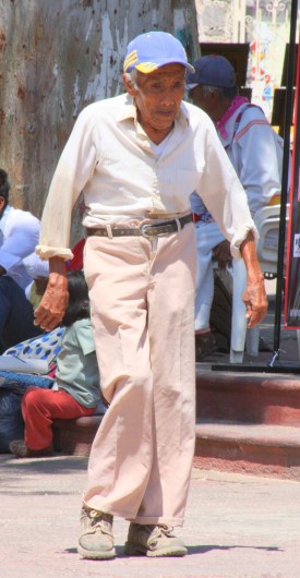 A viejo walks a cobblestone street in Chapala