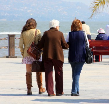 Three generations walk arm in arm along Jocotopec's malecon