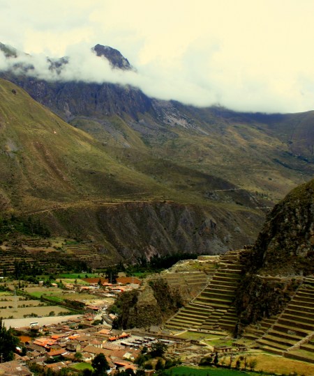 Town in foreground, ruins to right, quarry on the cloud-covered mountain.