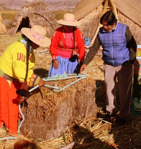 Uro women show how root blocks of floating reeds are lashed together.