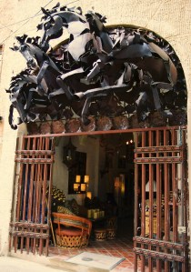 A herd of while horses in metal explodes onto the street.